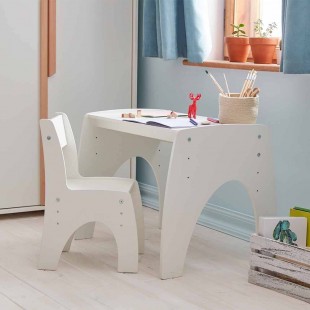 Petite table réglable blanche dans une chambre bébé avec chaise